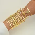 Elegant gold stacked bracelet set featuring various textured and geometric designs. - 打结印花款式(6553301HB) / 15pcs / Gold