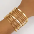 Elegante set di braccialetti rigidi dorati multistrato con finiture lisce e testurizzate - Set Sovrapposto Multistrato Misto (5982601)
