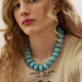 Un primer plano de un collar bohemio de cuentas gruesas azul claro usado por una modelo. - Estilo de Cuenta Redonda Grande / Azul Claro (6774304)