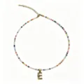 Dettaglio in primo piano della collana di perline colorate con ciondolo lettera E. - Lettera E