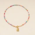 Collier de perles bohème coloré avec un pendentif lettre E doré chic. Vue détaillée. - Lettre E / Or