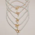 Elegante Perlenhalskette mit goldenem OT-Verschluss und funkelnden Strass-Initialen. - Buchstabe A