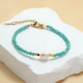 Nahaufnahme eines türkisfarbenen Kristallperlenarmbands mit einer echten Süßwasserperle. - Hellblau