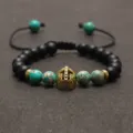 Türkis und schwarzer Lavastein geflochtenes Armband mit goldenem Spartanerhelm Anhänger. - Grün