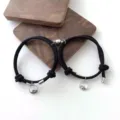 Detailaufnahme von Paar magnetischen schwarzen geflochtenen Seilarmbändern mit Wellen. - Ganz Schwarz