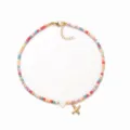 Nahaufnahme der bunten Perlenkette mit goldenem X und Herz-Anhänger im Boho-Stil. - Buchstabe X
