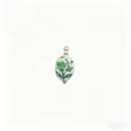 Nahaufnahme Detail des handbemalten gruenen floralen Keramik Ovals mit Metallringen. - Grün