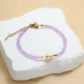 Paarse kristalen kralenarmband met zoetwaterparel en gouden metalen sluiting en ketting. - Paars