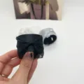 Detailansicht eines süßen schwarzen Spitzen-Bogen-Haarmanschetten-Accessoires in der Hand - Schwarz