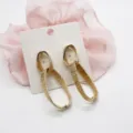 Detail showing the intricate texture of golden geometric linked earrings on a card - Double Loop Nested Circular (3)