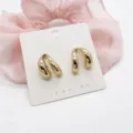 Macro detail view of gold geometric stud earrings with a high-polish alloy finish - Vintage Double Loop Geometric (6)