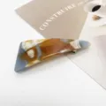 Detailed view of a geometric marble pattern resin hair clip on a minimalist background - Amber Agate Pattern (10)