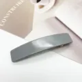 Vue détaillée d'une barrette rectangulaire grise en acétate sur fond esthétique clair - Gris Morandi (11)