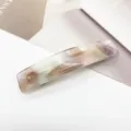 Gros plan d'une pince à cheveux rectangulaire élégante motif marbre. - Motif Fleur à l'Encre (8)