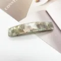 Gros plan d'une pince à cheveux rectangulaire en acétate avec motif de marbre vert - Motif de Pierres Concassées (6)