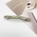 Close-up detail of a rectangular resin spring hair clip with green marble texture - Light Green Marble
