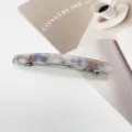Macro shot of a minimalist rectangular resin hair clip with blue marble pattern - Blue and Beige Marble