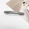 Detail shot of a minimalist grey resin rectangular hair clip on a white background. - Matte Grey
