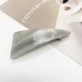 Macro view of the elegant grey marble resin hair clip with geometric triangular shape - Cool Gray Flowing Sand (2)