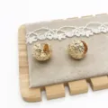 Detailed view of textured gold-colored circular earrings with a molten hammered finish. - Lava Hammered Texture (11) / Gold