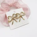 Close-up of gold-finish bow-shaped alloy stud earrings on a jewelry display card - Irregular Geometric Bowknot (14)