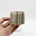 Close-up of pleated fabric ponytail hook hair accessory with shiny rhinestones - Khaki