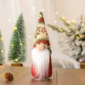 Primo piano di una simpatica bambola di gnomo natalizio con cappello lavorato e barba. - Berretto in Maglia Fiocco di Neve Verde