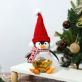 Vista dettagliata di un barattolo di caramelle pinguino di Natale con cappello e sciarpa - Barattolo di caramelle pinguino con cappello rosso