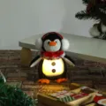Dettaglio dell'ornamento natalizio a forma di pinguino luminoso con sciarpa e paraorecchi - Ciondolo Pinguino Cappello Rosso