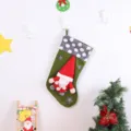 Nahaufnahme der grünen Weihnachtssocke mit grauem Plüschbündchen und 3D-Wichtelpuppe. - Stehender Weihnachtsmann grüne Socke