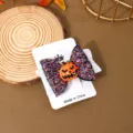 Halloween glitter bow hair clip with cute pumpkin detail, close-up shot on display card. - Resin Pumpkin