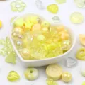 Close-up of mixed yellow acrylic beads in heart and star shapes for DIY jewelry making - 500g Pack / Yellow