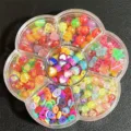 Detalle de cuentas de acrílico mezcladas en una caja de flores con siete compartimentos. - 500 Piezas/Paquete / Multicolor
