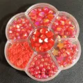 Vista detallada de cuentas rojas variadas para manualidades en caja con forma de flor - 500 Piezas/Paquete / Rojo