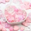 Close-up of mixed pink acrylic beads in a heart bowl for DIY jewelry and phone charms. - 500g Pack / Pink