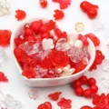 Detail shot of various red and clear acrylic mixed beads inside a heart-shaped ceramic bowl - 500g Pack / Red