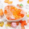 Close-up of colorful mixed shape acrylic beads and charms in a heart-shaped bowl - 500g Pack / Orange