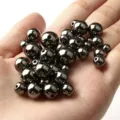 Vue détaillée de perles CCB métalliques gunmetal dans la main pour la création de bijoux - 10mm/500g/880 Pièces / Métal canon
