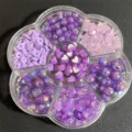 Detalle macro de varias cuentas de bricolaje moradas con formas de corazón y estrella - 500 Piezas/Paquete / Púrpura