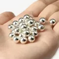 Vista macro de cuentas de CCB plateadas pulidas en la mano para joyería DIY artesanal. - 10mm/500g/880 Piezas / Imitación Plata