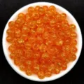 Macro view of 8mm orange crackle acrylic beads inside a white bowl for DIY jewelry - Orange