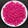 Close-up of 8mm magenta transparent crackle acrylic beads in a white dish - Rose Red