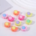 Vista macro de varias cuentas acrílicas de colores con forma de caracol para joyas DIY - 320 Piezas Por 500g