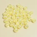 Macro view of 8mm iridescent pale yellow acrylic round beads with shimmering AB finish - 8mm / Yellow