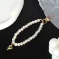 Macro detail of elegant white pearl strap featuring a gold-plated letter P charm and clasp - Letter P(P)