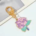 Vue détaillée du charme d'hortensia en émail coloré sur un porte-clés en métal doré - Boule de Fleur Rose Violet