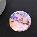 Primer plano de un imán de nevera circular de París con ilustración de la Torre Eiffel - París