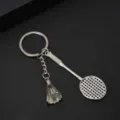 Detaillierte Nahaufnahme der Metallstruktur des silbernen Badmintonschläger-Schlüsselanhängers - Silber