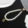 Close-up detail of an elegant white pearl phone chain with a gold metal letter R charm - Letter R(R)