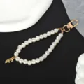 Detail view of white pearl keychain with a gold-plated letter F charm and metal clasp - Letter F(F)